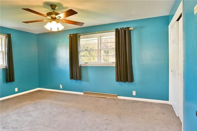 carpeted spare room with ceiling fan