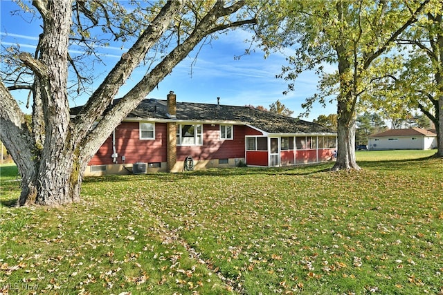 back of property with a yard, a sunroom, and cooling unit