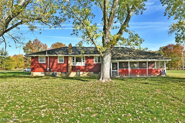 back of house featuring a sunroom, a lawn, and central AC unit