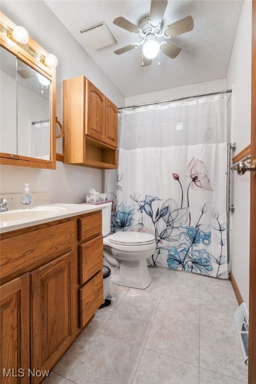 bathroom featuring vanity, a textured ceiling, toilet, and ceiling fan