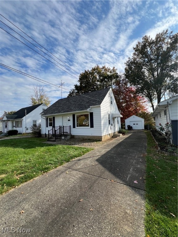 view of front of property with an outdoor structure, a garage, and a front lawn