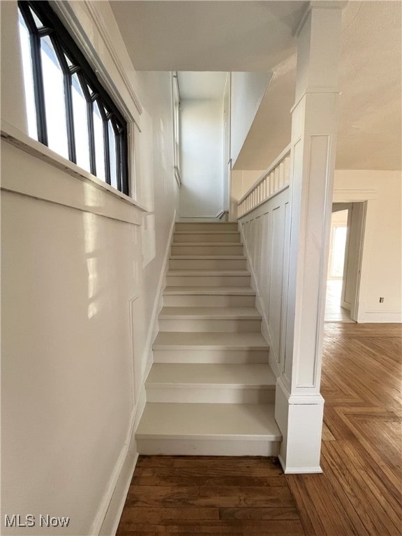 staircase featuring hardwood / wood-style flooring and plenty of natural light