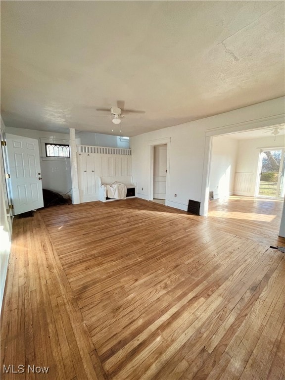 unfurnished living room featuring light wood-type flooring and ceiling fan