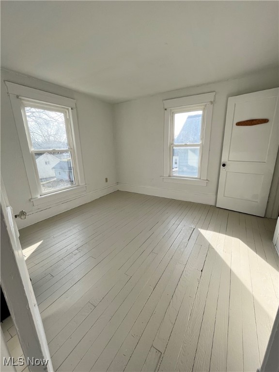 unfurnished room featuring light hardwood / wood-style flooring and plenty of natural light