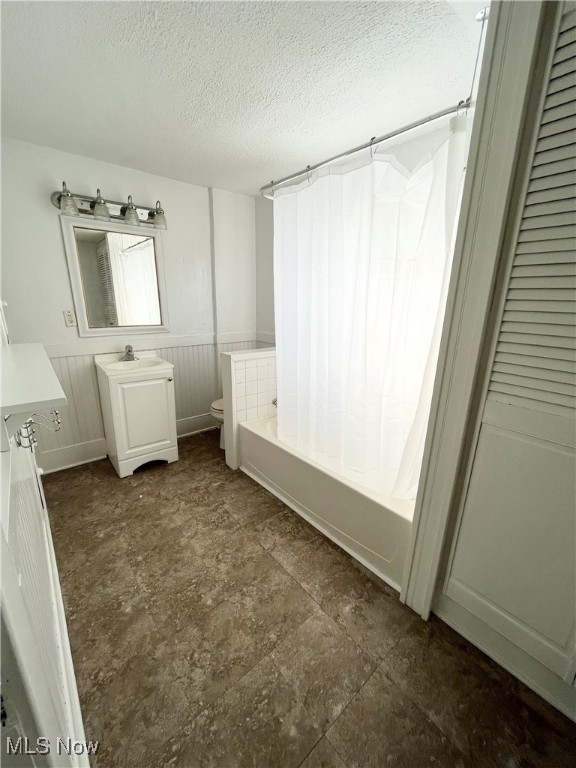 bathroom with vanity, a textured ceiling, and toilet