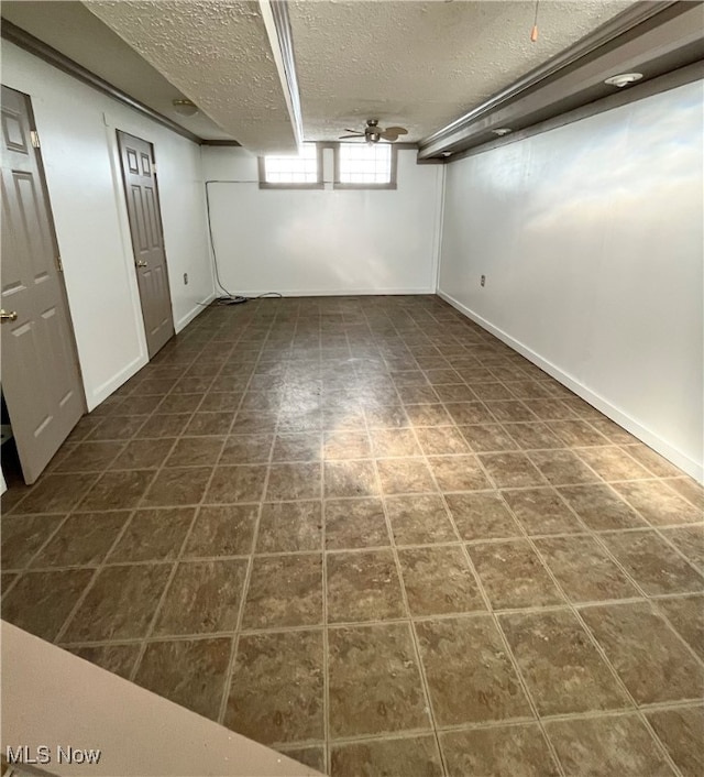 basement with dark tile patterned floors and a textured ceiling