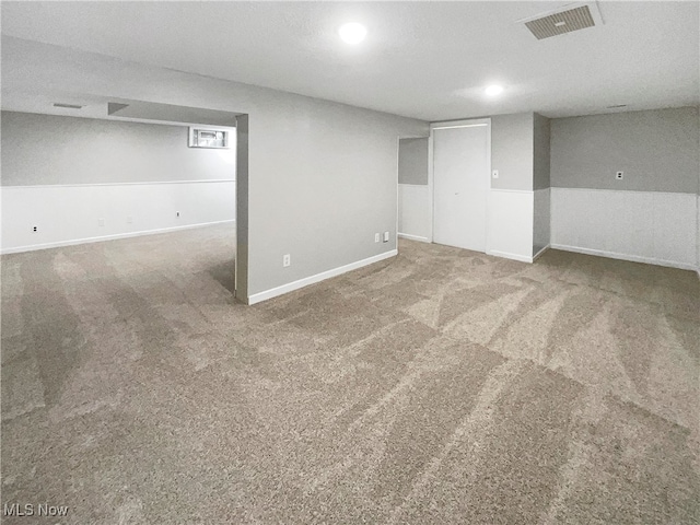 basement featuring a textured ceiling and carpet