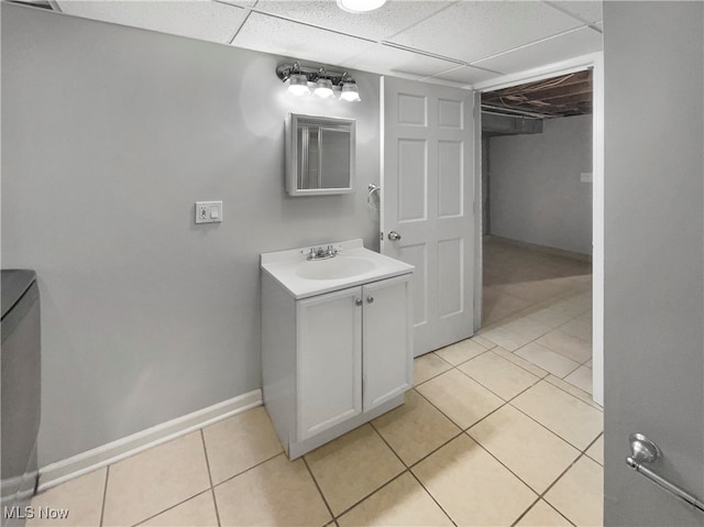 bathroom with vanity, a drop ceiling, and tile patterned floors