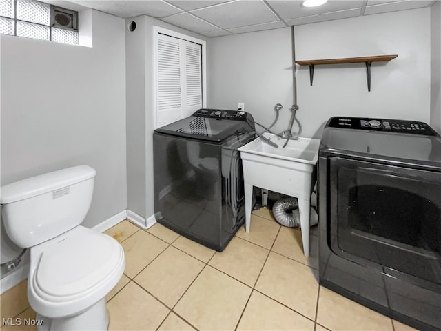 clothes washing area featuring washer and dryer and light tile patterned floors