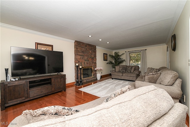 living room with crown molding, a stone fireplace, hardwood / wood-style flooring, and a textured ceiling