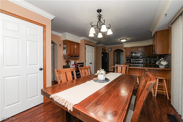 dining space featuring crown molding, a notable chandelier, and dark hardwood / wood-style flooring