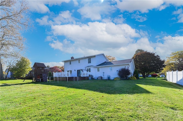 rear view of house featuring a playground and a yard