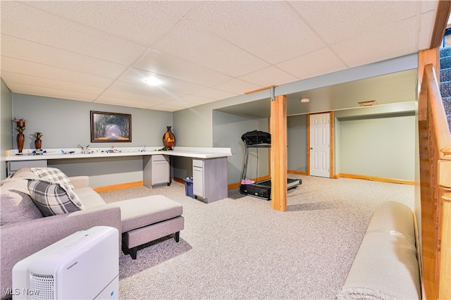 living room with a drop ceiling and light carpet