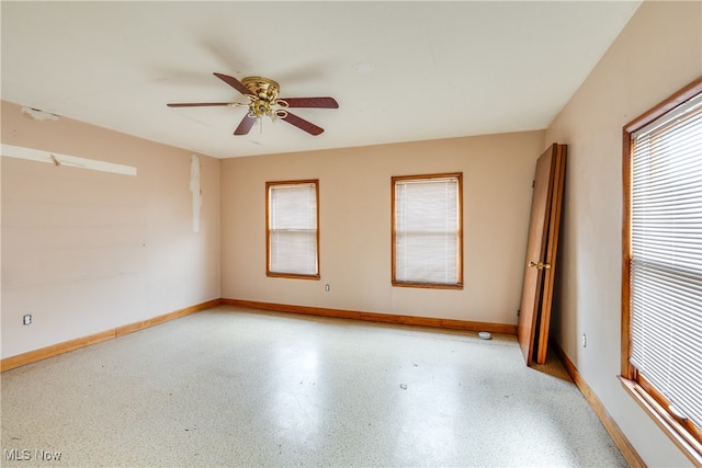 unfurnished room with ceiling fan and plenty of natural light