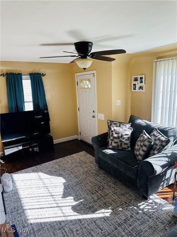 living room with dark hardwood / wood-style flooring, a wealth of natural light, and ceiling fan