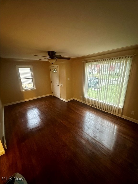 empty room with ceiling fan and dark wood-type flooring