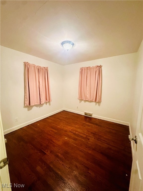 empty room with dark wood-type flooring