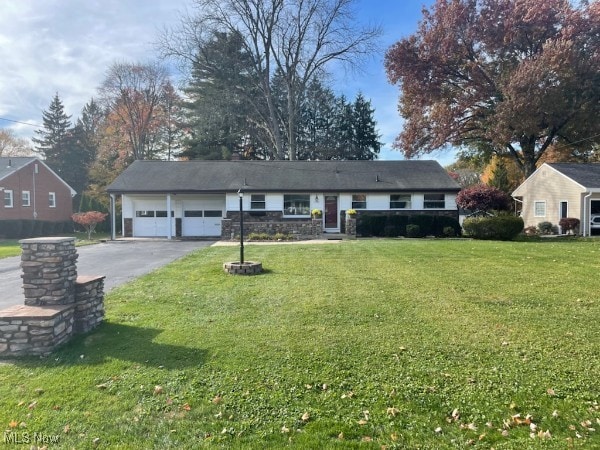 ranch-style home featuring a front lawn and a garage