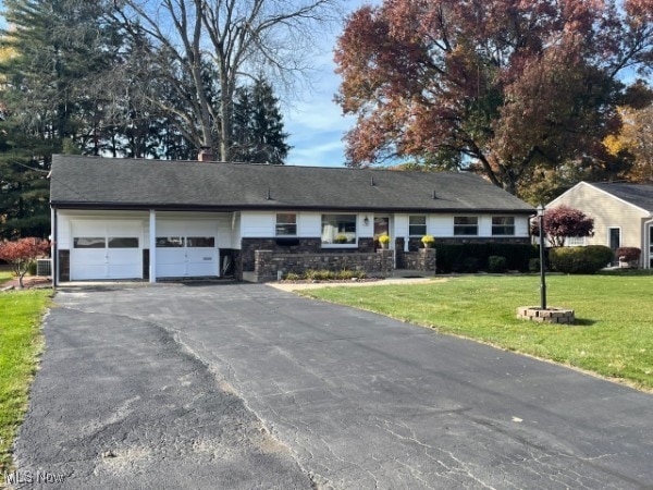 single story home featuring a front lawn and a garage