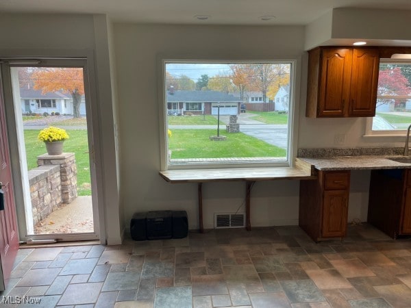 kitchen with a healthy amount of sunlight, built in desk, and sink