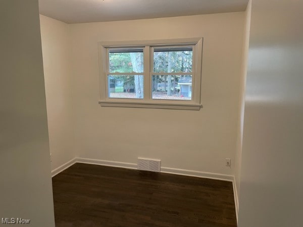 unfurnished room with dark hardwood / wood-style floors