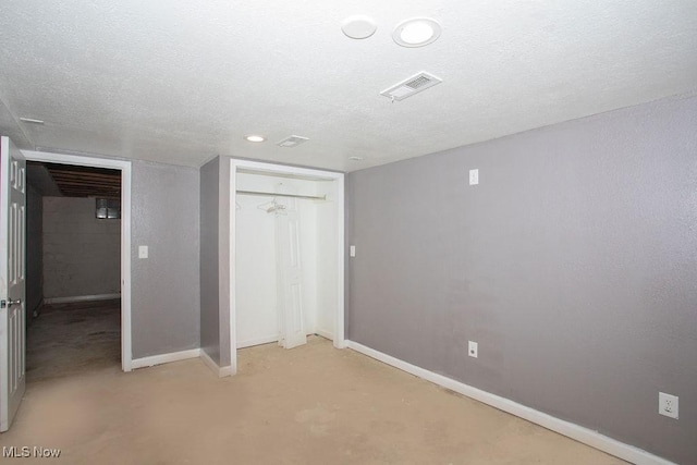 unfurnished bedroom featuring a textured ceiling and a closet