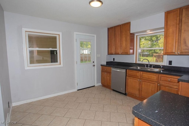 kitchen with stainless steel dishwasher, light tile patterned floors, sink, and a wealth of natural light