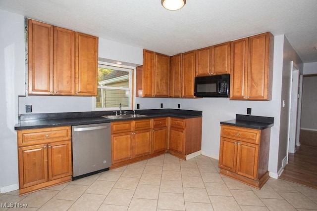 kitchen featuring sink, light tile patterned flooring, and stainless steel dishwasher