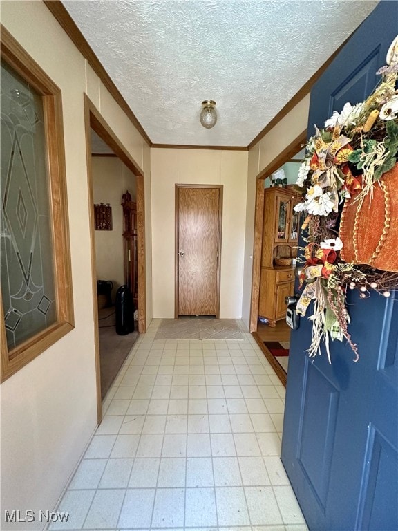 entryway featuring ornamental molding and a textured ceiling