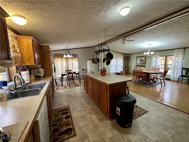 kitchen with sink, a center island, hanging light fixtures, and a textured ceiling