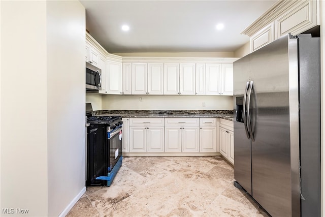 kitchen featuring white cabinetry, appliances with stainless steel finishes, and dark stone counters