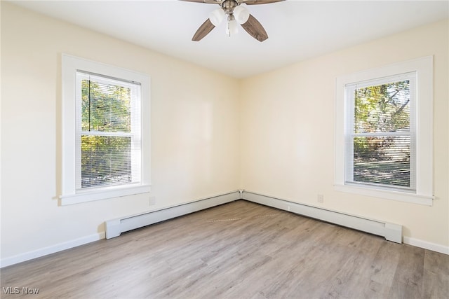 empty room with baseboard heating, a healthy amount of sunlight, light wood-type flooring, and ceiling fan