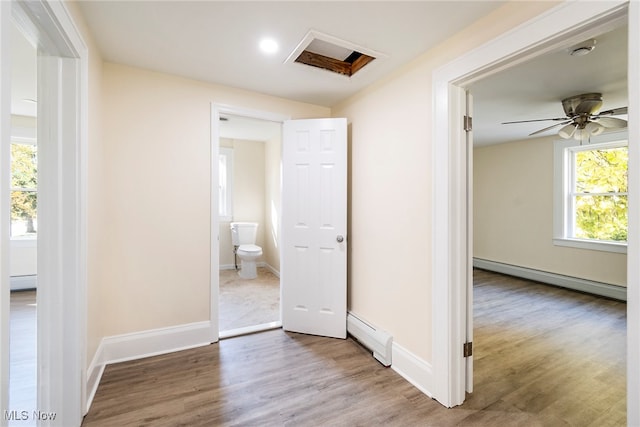 hallway featuring baseboard heating and hardwood / wood-style flooring