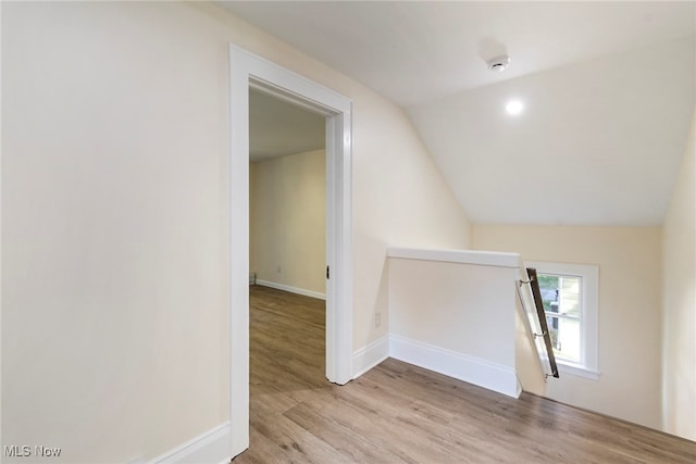 additional living space featuring lofted ceiling and light hardwood / wood-style flooring