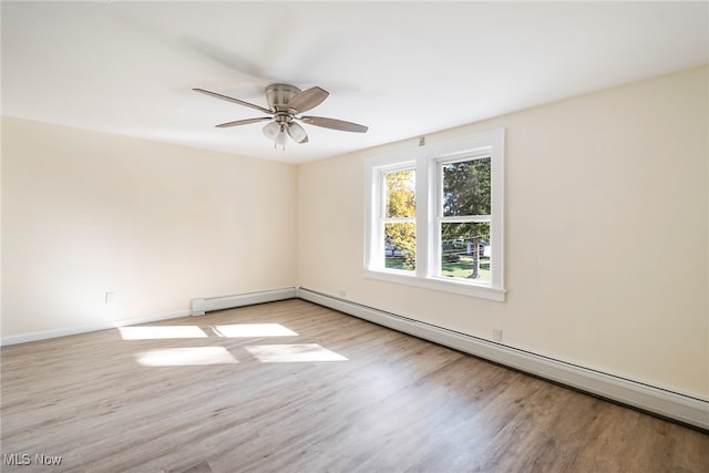 spare room featuring baseboard heating, light hardwood / wood-style floors, and ceiling fan