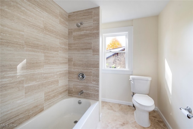 bathroom with tiled shower / bath, tile patterned floors, and toilet