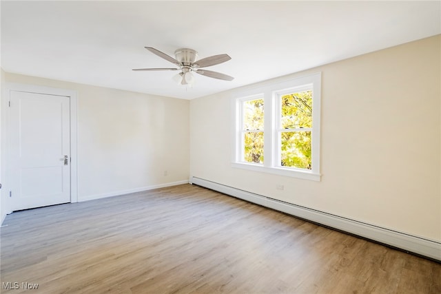 empty room with light hardwood / wood-style floors, a baseboard heating unit, and ceiling fan