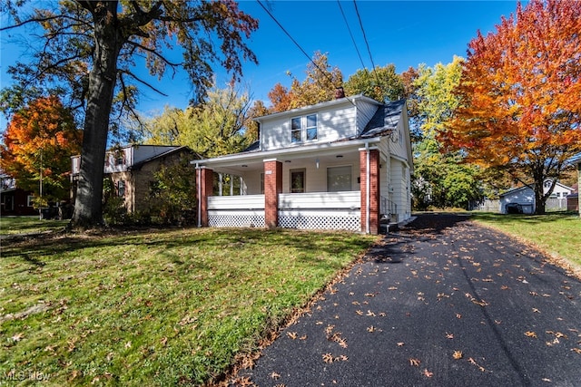 view of front of house with a front yard and a porch