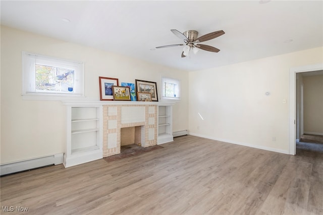 unfurnished living room featuring light hardwood / wood-style floors, baseboard heating, plenty of natural light, and a brick fireplace