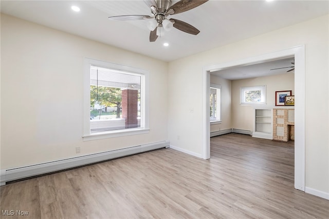 empty room with light hardwood / wood-style floors, baseboard heating, plenty of natural light, and ceiling fan