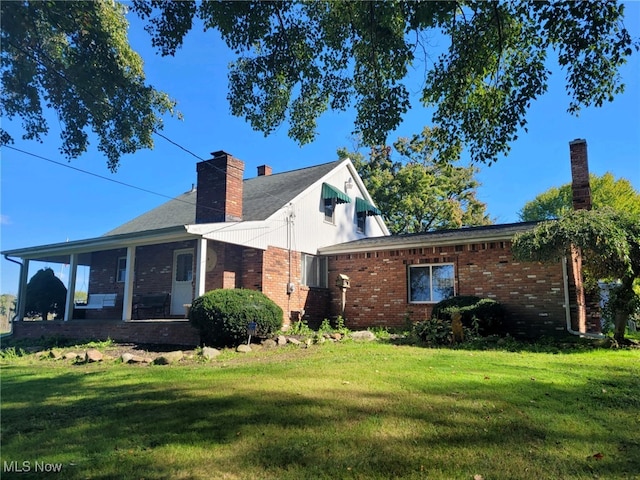 rear view of house featuring a lawn