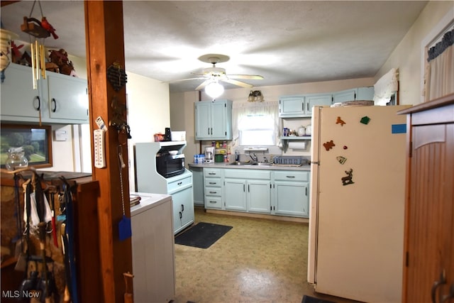 kitchen with ceiling fan, white refrigerator, and sink