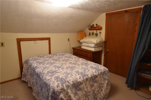 bedroom featuring a textured ceiling, light carpet, and vaulted ceiling