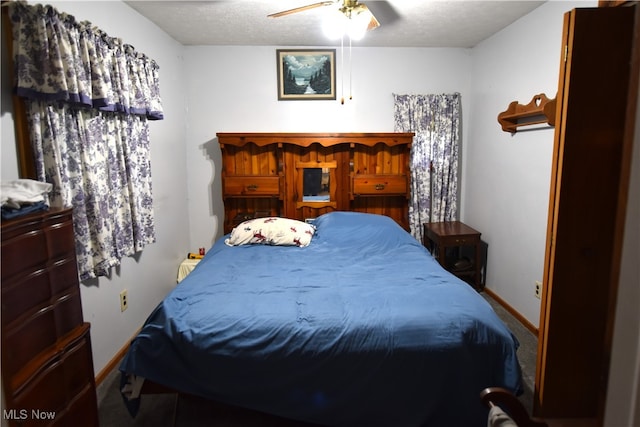 bedroom featuring ceiling fan, carpet floors, and a textured ceiling