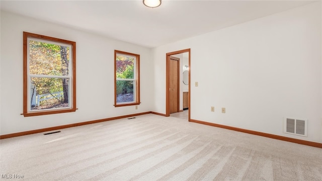 empty room with plenty of natural light and light colored carpet