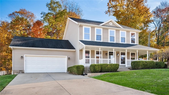 view of front facade with covered porch, a front yard, and a garage