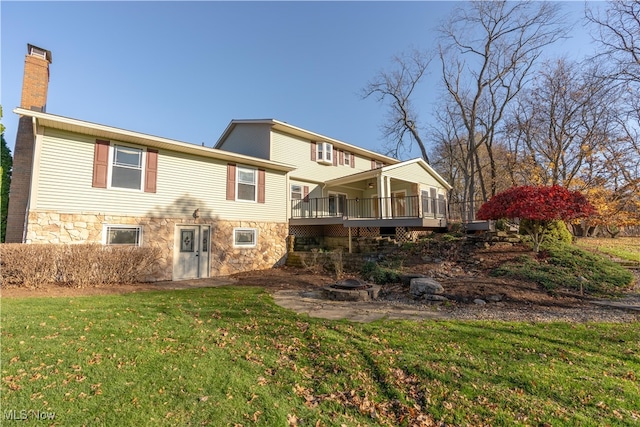 rear view of house with a lawn and a wooden deck