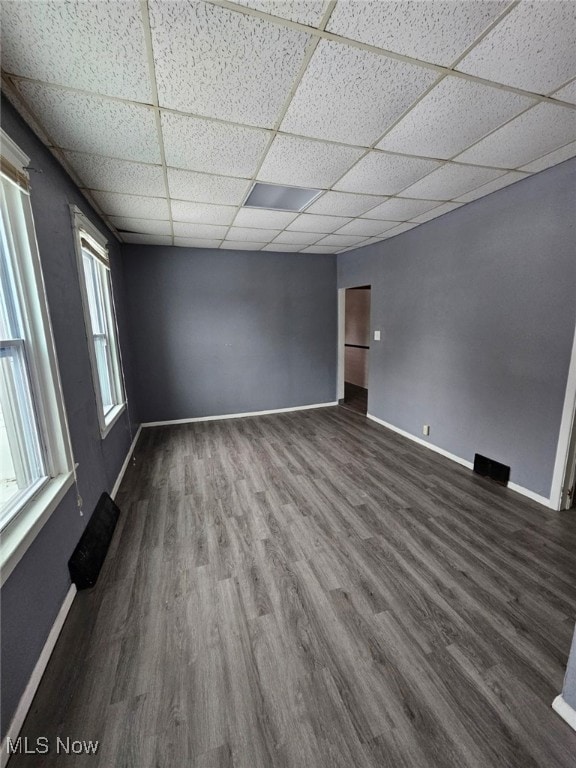 spare room with a drop ceiling and hardwood / wood-style flooring