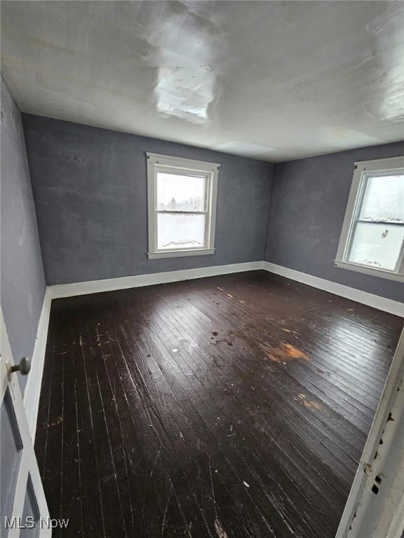 spare room featuring hardwood / wood-style floors and a wealth of natural light