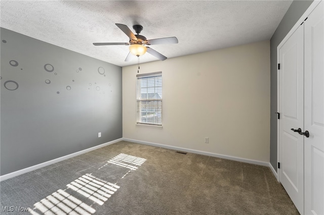 unfurnished bedroom with a textured ceiling, carpet floors, a closet, and ceiling fan